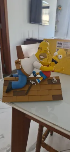 Estatua do Homer vs Bart no telhado da linha Iron Studios