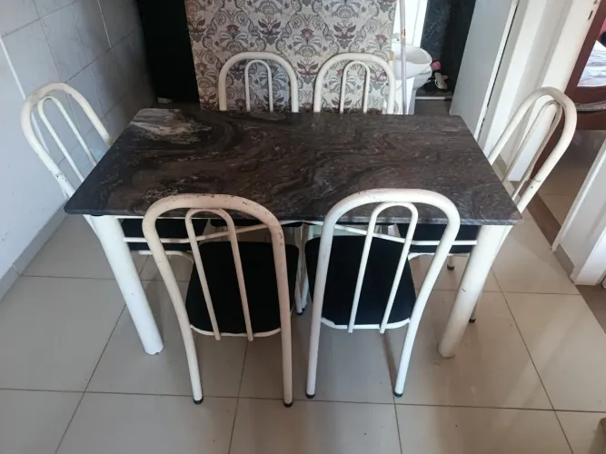 Mesa de mármore com pouco anos de uso mármore novo cadeiras brancas com o acento preto