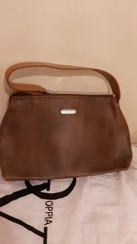 Bolsa de couro sintético, cor marrom com alças claras, divisões internas, marca