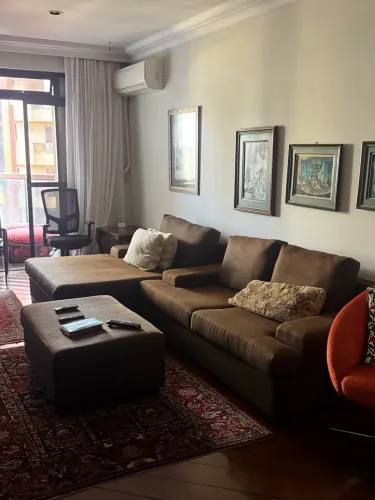 Sofá modular marrom possui uma chaise longa e um pufe retangular