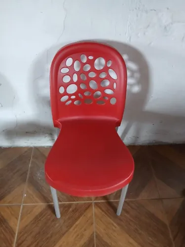 Cadeira vermelha de plástico com pés metálicos