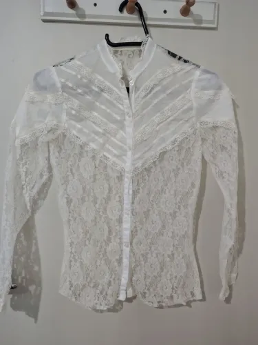 Camisa branca em renda, com detalhes na pala, usada