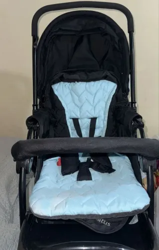 Carrinho de bebê com o bebê conforto.