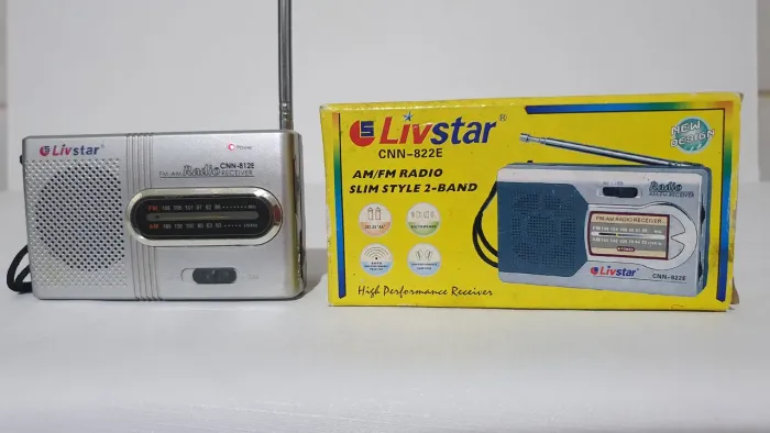 Rádio portátil AM/FM Livstar a pilha funcionando na caixa