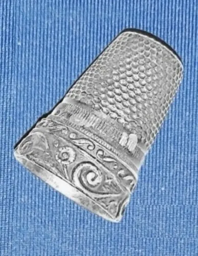 Dedal antigo em metal trabalhado prateado