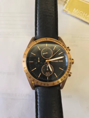 Relógio Michael kors day just com caixa dourada e mostrador preto.
