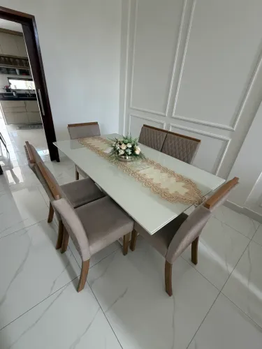 Mesa de jantar com tampo de vidro, acompanhada de 6 cadeiras.