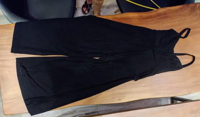 Macacão preto tipo pantalonga com alças e pouco brilho