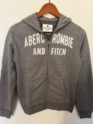 moletom abercrombie kids na cor cinza, tamanho 11/12. possui zíper frontal, capuz e bolsos