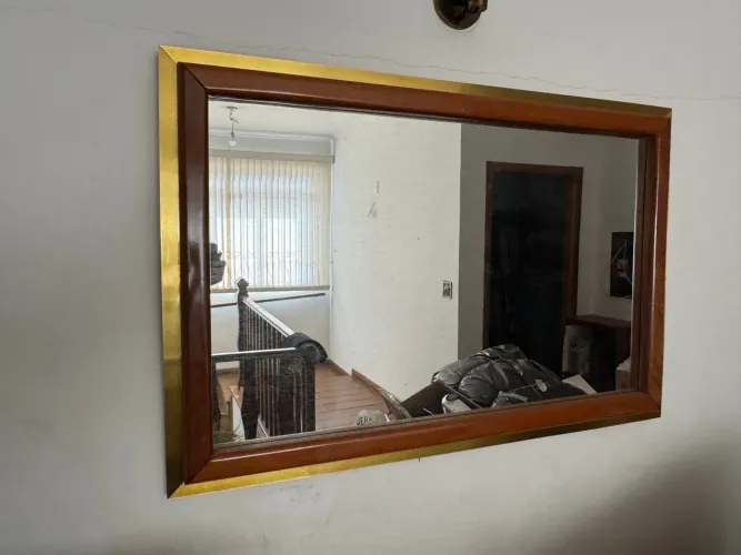 Espelho decorativo com moldura em madeira e detalhes dourados