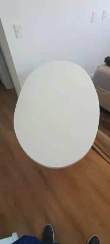 Mesa oval com tampo em vidro, base em madeira e pés em aço e concreto