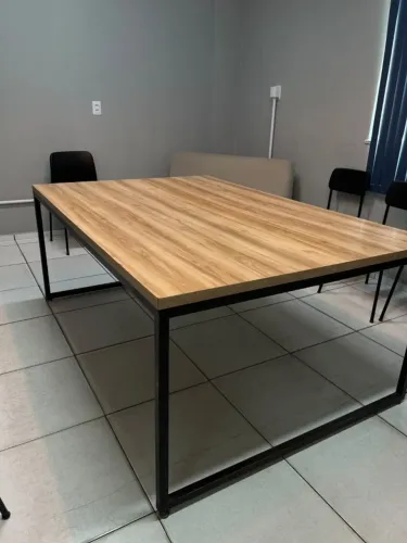 Mesa de reunião grande amadeirada com estrutura metálica