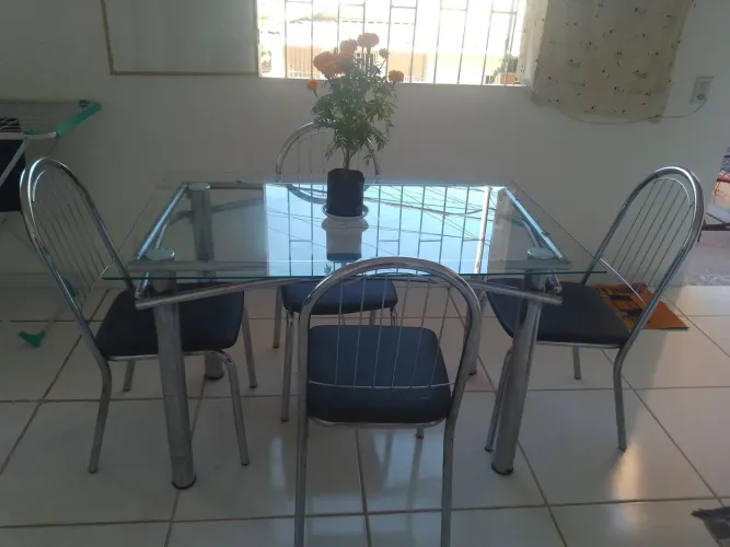 Mesa de vidro com 4 cadeiras.