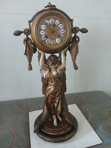 Relógio encima de estatueta 