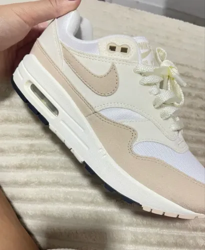 Tênis Nike Air Max 1 Pale Ivory feminino com cabedal em tons neutros e camurça arenosa.