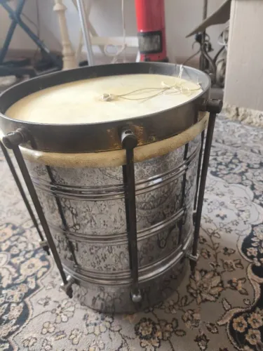 Cuíca de inox com pele natural, acompanhada de sua capa protetora de transporte