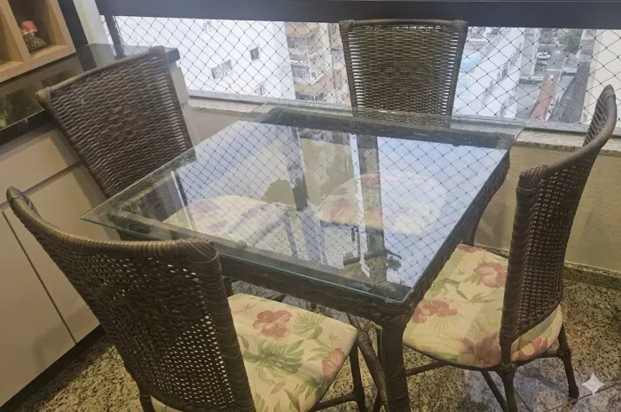 Mesa de vidro com 4 cadeiras.
