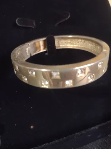 Bracelete rígido folheado a ouro com fechamento em imã com strass cravejados
