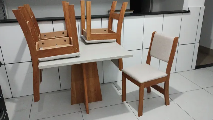 Mesa com quatro cadeiras estofadas.