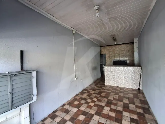 Salão comercial com banheiro e porta de aço.