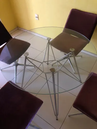 Mesa de vidro com quatro cadeiras.