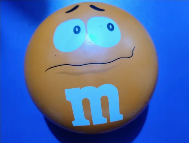 Lata m&m laranja vazia.<br>