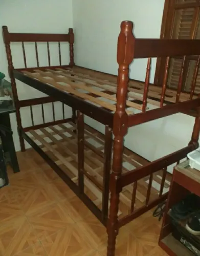 Cama beliche em madeira maciça com colchão.