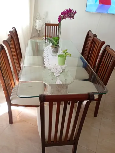 Mesa de vidro grosso e pés de mármore, acompanha 8 cadeiras de madeira maciça