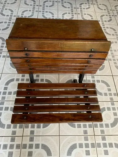 Carteira escolar antiga com pés de ferro.