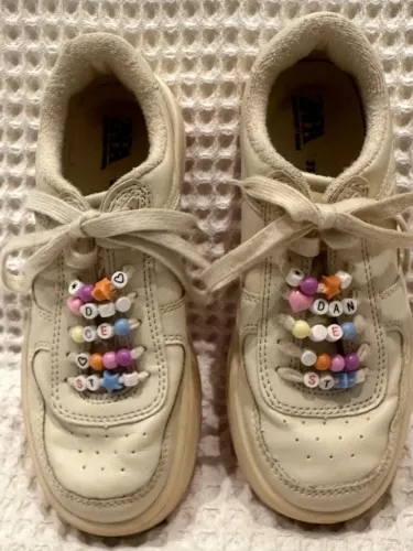 tênis infantil off-white decorado com miçangas coloridas enfileiradas nos cadarços, 33
