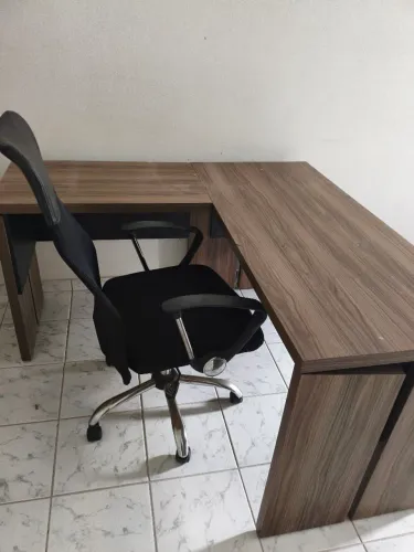 Mesa L para escritório com cadeira.