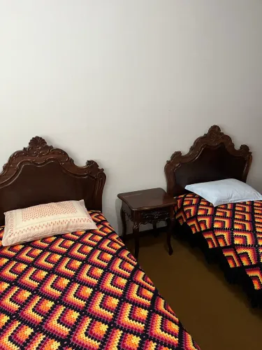 Camas de solteiro e mesa de cabeceira em madeira maciça, com entalhes