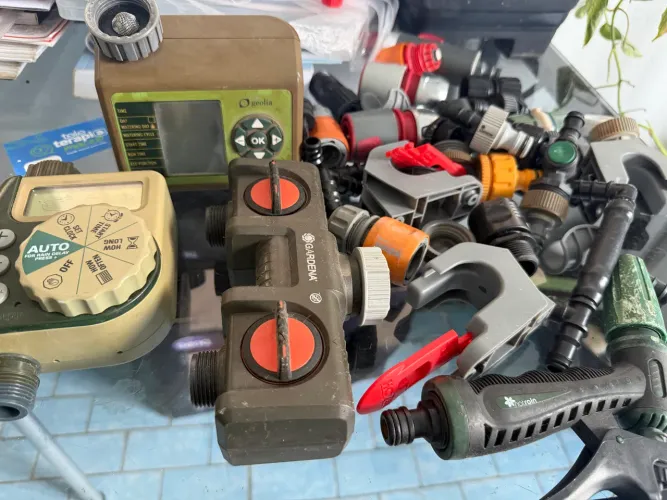 conjunto de equipamentos para automação de irrigação de jardins e conexões de mangueira.