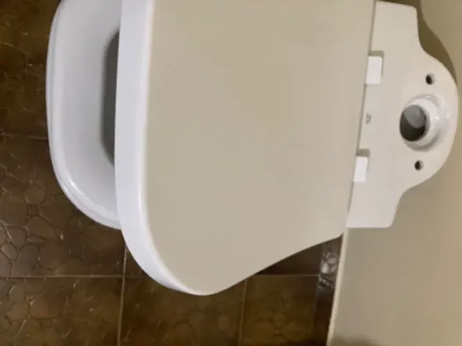 Vaso sanitário com caixa acoplada marca Deca e um nicho de pedra de mármore 