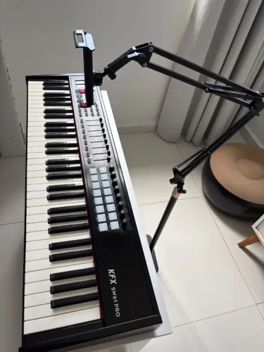 controlador midi de 61 teclas, KFX SW61 PRO, com suporte articulado para tablet e celular.