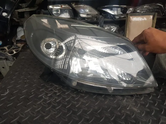 Renault farol Sandero Stepway modelo antigo. Lado direito. Fundo cinza. 