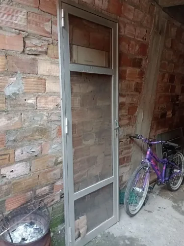Vendo porta de alumínio e vidro.2'10×0'70.porem tá com o vidro de baixo danificado.