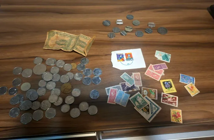 Moedas selos e ficha telefônica antiga