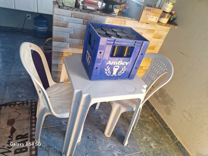 Vendo essa mesa de plástico com duas cadeiras e uma grade de cerveja litrão vazia