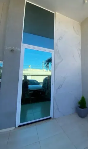 Porta de vidro com puxador em alumínio.