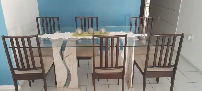 Mesa de vidro com base de mármore e seis cadeiras estofadas de madeira