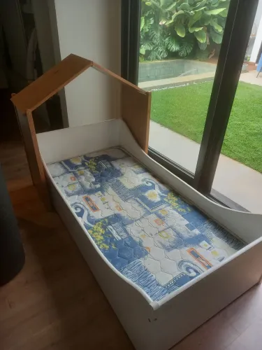 Cama infantil tok stok com colchão e cabeceira.