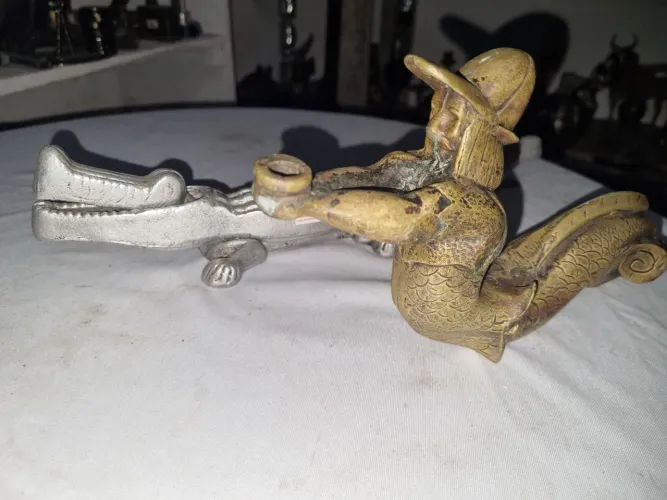 2 itens sendo uma peça de bronze desconhecida e uma outra um outro tipo de metal