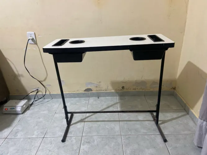 Mesa de manicure à venda! Branca, com estrutura preta e porta-produtos.