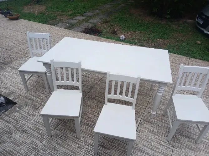 Mesa para refeições com 4 cadeiras brancas.Tampo da mesa mede 1,80cm× 0,88cm marcas de uso