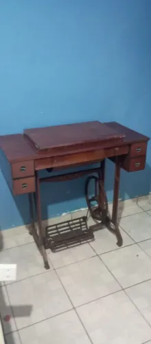 Máquina de costura antiga com gabinete de madeira