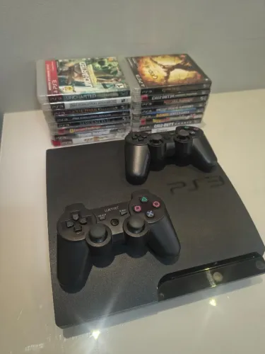 playstation 3 slim, na cor preta. acompanha 2 controles e 16 jogos