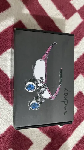 Lupa binocular cirúrgica com luz LED integrada.