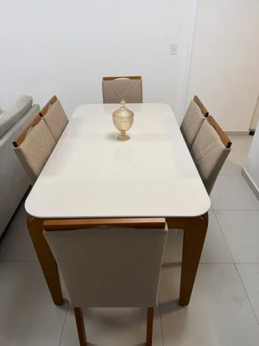 Mesa 6 lugares com cadeiras estofados.
