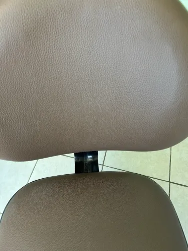 Cadeira Giroflex sem braços com regulagem de altura cor marrom.